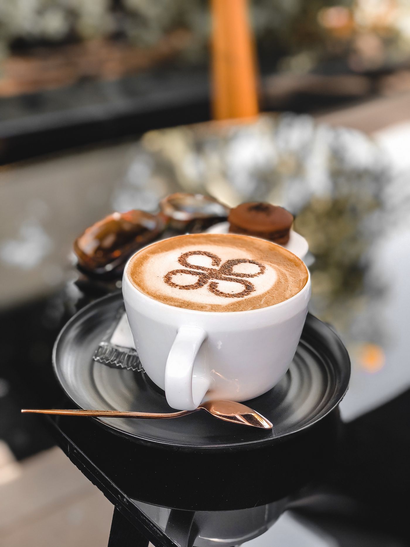 Cappuccino avec art latte, servi avec une pâtisserie